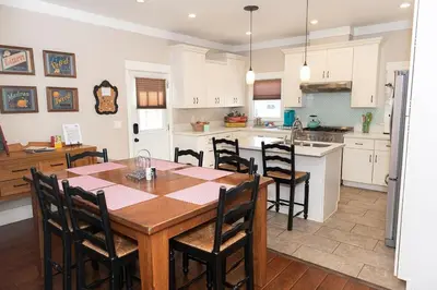 a kitchen and dining room with a wooden table and chairs at Historic craftsman sleeps 9 3br2.5ba Disney 1mi in Anaheim