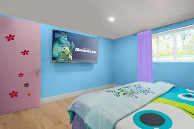 a room with a bed with a tv on the wall at Imagination Kingdom by OC Adventure Homes in Garden Grove