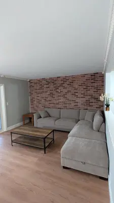 a living room with two couches and a brick wall at Serene home in Simi valley, CA in Simi Valley