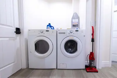 a washing machine and a mop in a laundry room at Modern Luxe Ensuite by USC Shared Living in Los Angeles