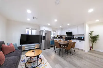 a living room with a couch and a table and a kitchen at Modern Luxe Ensuite by USC Shared Living in Los Angeles