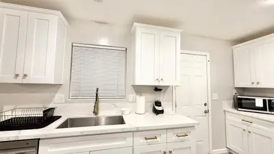 a white kitchen with a sink and a microwave at LRG 1600sqft 4room 2 bath in a quiet neighborhood in Bakersfield