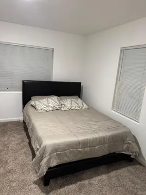 a bed in a bedroom with a black headboard at LRG 1600sqft 4room 2 bath in a quiet neighborhood in Bakersfield