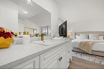 a white bathroom with a bed and a sink at Modern Private 3B-2BA Home and Spacious Yard in Lancaster