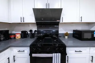 a kitchen with a black stove and a microwave at Modern Private Room in Shared Home -Walk to USC in Los Angeles