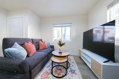 a living room with a couch and a flat screen tv at Modern Private Room in Shared Home -Walk to USC in Los Angeles
