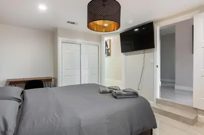 a bedroom with a bed with a gray blanket on it at Spacious 5 BR Brand New House LAX in Inglewood