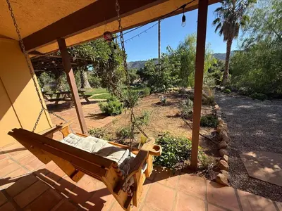 a swing hanging from a porch of a house at Paradise at Tree Ranch Grove in Ojai