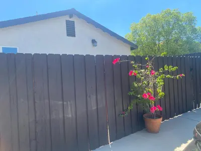 a fence with a plant in front of a house at Cozy Home Away From Home in Northridge Hospital Heliport