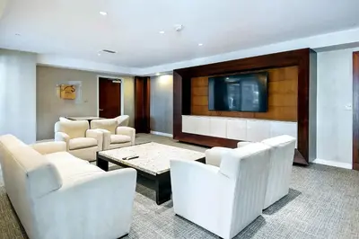 a living room with white chairs and a flat screen tv at Platinum Suites - Gym & Pool & Hot Tub & BBQ in Los Angeles