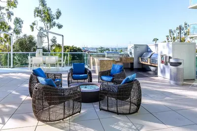 a patio with chairs and a table on a roof at Platinum Suites - Gym & Pool & Hot Tub & BBQ in Los Angeles