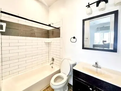 a white bathroom with a toilet and a sink at Lovely 3-bedroom house with AC in vibrant Los Angeles Near USC in Los Angeles