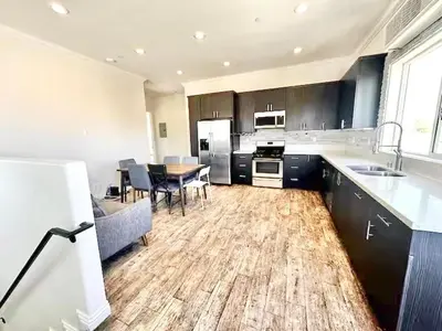 a large kitchen with a table and a dining room at Lovely 3-bedroom house with AC in vibrant Los Angeles Near USC in Los Angeles