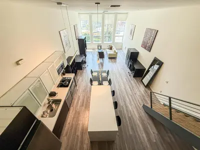 a living room with a long table and a kitchen at Stylish 2BR Loft with Top-Tier Amenities - 104 - GL in Glendale