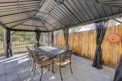 a patio with a table and chairs and a fence at Beautiful Lake-View House Walk to Lake and Village! in Big Bear Lake