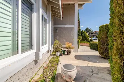 a porch of a house with potted plants on the sidewalk at Spacious 4-bedroom family house-20 mins to Disney Land in Rowland Heights