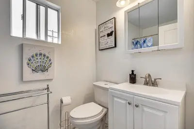 a white bathroom with a toilet and a sink at Near Hospitals and Metrolink Access LA Getaway in Los Angeles