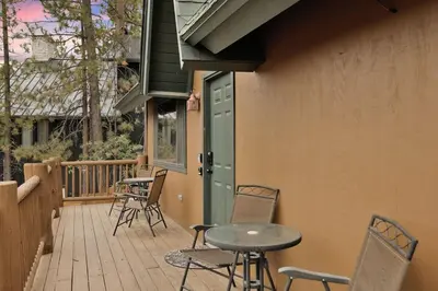 a patio with chairs and a table on a deck at Lakeview Pines Log Cabin - Custom Built Village Log Cabin Retreat w/ Hot Tub, Pool Table in Big Bear Lake