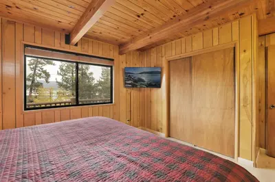a bedroom with a large bed with a window at Lakeview Pines Log Cabin - Custom Built Village Log Cabin Retreat w/ Hot Tub, Pool Table in Big Bear Lake