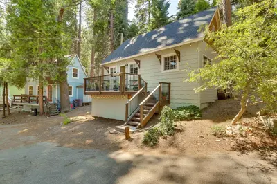 a white house with a porch and stairs to it at Hike, Ski, Relax Mtn Getaway in Lake Arrowhead in Lake Arrowhead