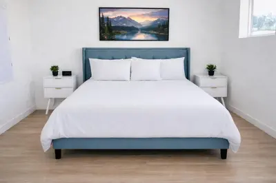 a bedroom with a large bed with a blue headboard at Heart of Hollywood Walk of Fame - Free Parking, Pool, Gym, Rooftop Views, centrally located, WIFI in Los Angeles
