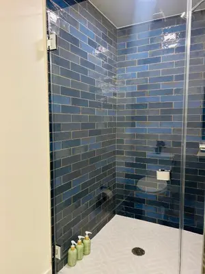 a blue tiled shower with a glass door at Heart of Hollywood Walk of Fame - Free Parking, Pool, Gym, Rooftop Views, centrally located, WIFI in Los Angeles