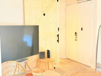 a living room with a tv and a wooden wall at Luxury stay by Gaia Homes in Los Angeles