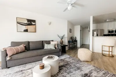 a living room with a gray couch and a kitchen at Ocean Breeze Retreat in Los Angeles