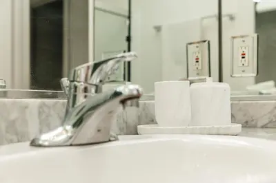 a bathroom sink with a faucet and rolls of toilet paper at Ocean Breeze Retreat in Los Angeles