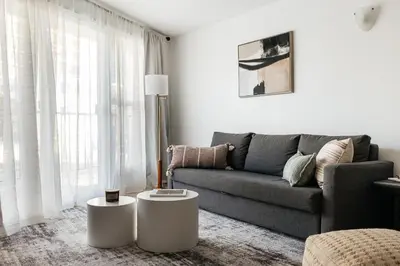 a living room with a couch and two white tables at Ocean Breeze Retreat in Los Angeles