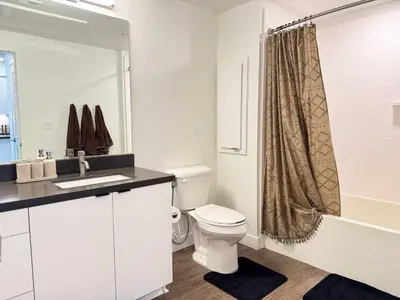 a bathroom with a toilet and a shower curtain at Luxury Stay Near Disneyland With Pool Gym & Free Parking in Santa Ana