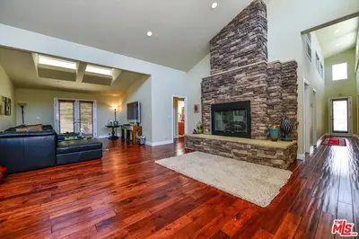 a living room with a couch and a stone fireplace at Beautiful, Spacious Agoura Malibu Zen House in Agoura Hills