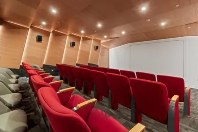 a lecture room with red chairs and a screen at Relax and recharge in this elegant 2BR loft - 108 - GL in Glendale