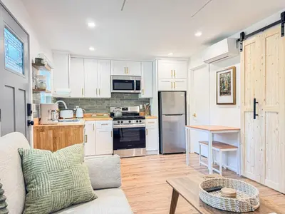 a kitchen with white cabinets and a couch and a table at Cozy Designer Guesthouse with Style - RE in Calabasas