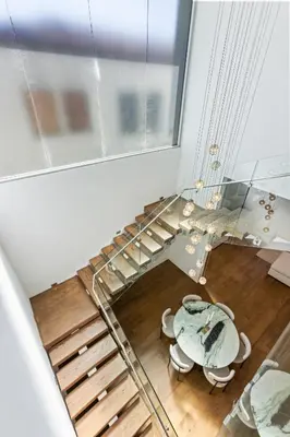 a room with a staircase and a table and chairs at 5BR Modern West Hollywood Retreat in Los Angeles