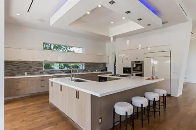 a kitchen with a large island with bar stools at 5BR Modern West Hollywood Retreat in Los Angeles