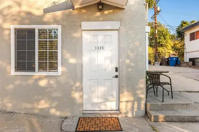 a white door on a building with a chair at Echo Park Spacious Two-Bedroom Apartment with Private Yard and Parking in Los Angeles