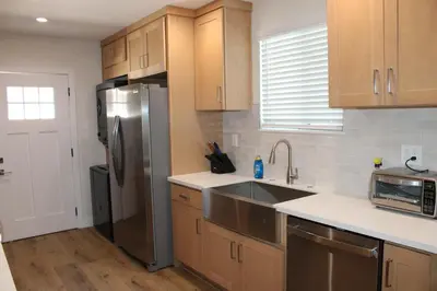 a kitchen with a stainless steel refrigerator and wooden cabinets at Newly Renovated La Habra 3bed 2 Bath in La Habra
