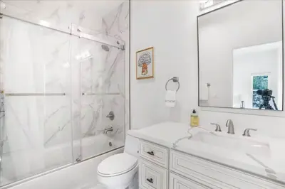 a white bathroom with a shower and a toilet and a sink at Newly Built Pasadena Retreat Parking Great Location in Pasadena