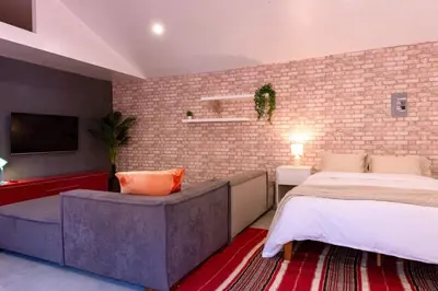 a bedroom with a bed and a brick wall at Modern Private Guesthouse with Parking, Yard, and Washer Dryer in Inglewood