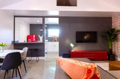 a living room with a red couch and a kitchen at Modern Private Guesthouse with Parking, Yard, and Washer Dryer in Inglewood