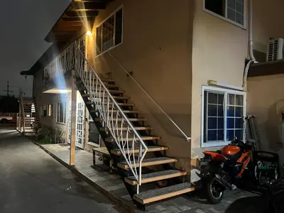 a motorcycle parked in front of a building with a staircase at 9621 San Juan - South Gate CA - Quick Drive to Hollywood & Beaches in South Gate