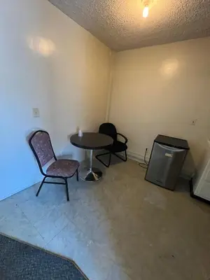a room with a table and two chairs and a table at York Motel in Los Angeles