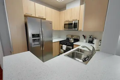 a kitchen with a stainless steel refrigerator and a sink at Quiet 1- bedroom condo near LAX, SoFi, and the Beach in Los Angeles