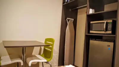 a small kitchen with a table and a microwave at Jewel City Inn in Glendale