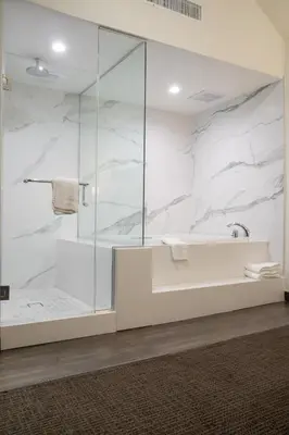 a bathroom with a glass shower and a sink at Hotel Xilo Glendale in Glendale