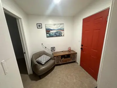 a living room with a red door and a chair at Desert Oasis Retreat in Barstow in Barstow