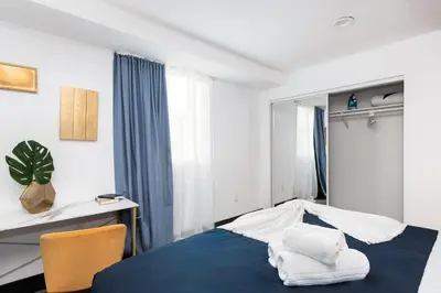 a bedroom with a blue bed and a chair at Spacious Luxury Villas in the heart of LA! Free parking and Jacuzzi in Los Angeles