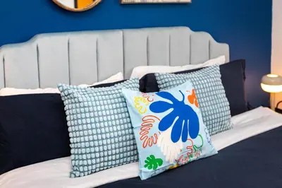 a bed with blue walls and pillows on it at Spacious Luxury Villas in the heart of LA! Free parking and Jacuzzi in Los Angeles