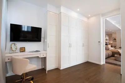 a white room with a desk and a tv on a wall at Modern 2BR Oasis with BBQ Sauna & Private Yard in Los Angeles